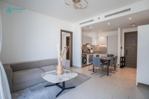 a living room with a couch and a table at Blue Breeze - 2 Bedroom near Downtown, Elegant Retreat in Sobha in Dubai