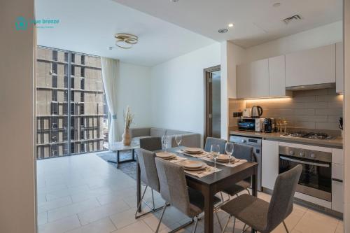 a kitchen and dining room with a table and chairs at Blue Breeze - 2 Bedroom near Downtown, Elegant Retreat in Sobha in Dubai