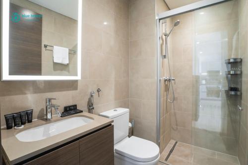 a bathroom with a toilet and a sink and a shower at Blue Breeze - 2 Bedroom near Downtown, Elegant Retreat in Sobha in Dubai