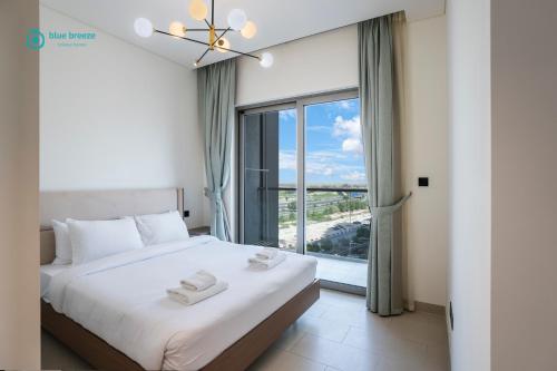 a bedroom with a bed and a large window at Blue Breeze - 2 Bedroom near Downtown, Elegant Retreat in Sobha in Dubai