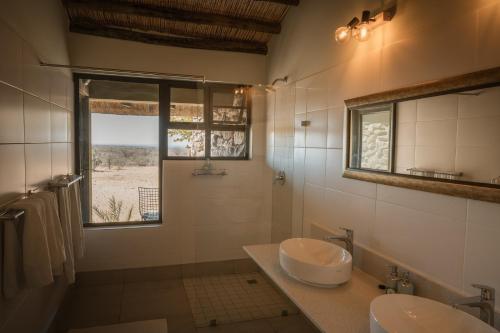 ein Badezimmer mit zwei Waschbecken und einem Fenster in der Unterkunft Kalahari Bush Breaks Lodge in Buitepos