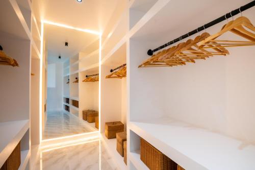 a walk in closet with white walls and wooden shelves at Bangkok Luxury Private Pool & Jacuzzi Villa , Daily Maid in Bang Bua Thong