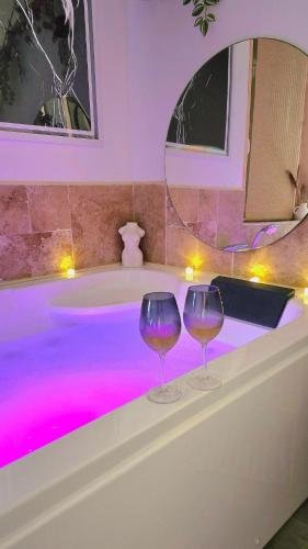 two wine glasses sitting on top of a bath tub at L'instant d'évasion Vue mer in Lampaul-Plouarzel