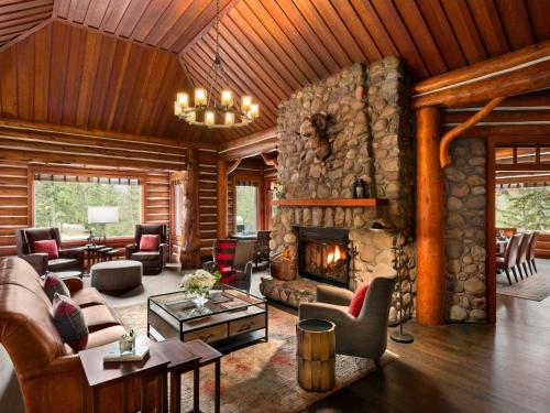 a large living room with a stone fireplace at Fairmont Jasper Park Lodge in Jasper