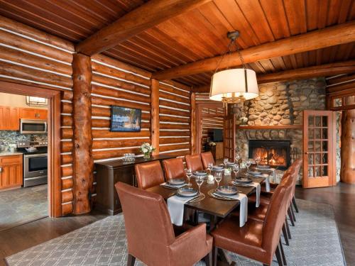 a dining room with a table and a fireplace at Fairmont Jasper Park Lodge in Jasper