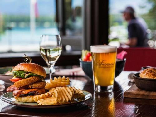 a table with a plate of food and a glass of beer at Fairmont Jasper Park Lodge in Jasper
