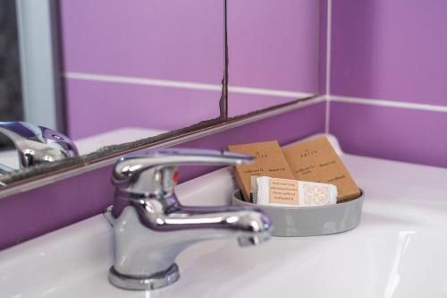 a sink with two boxes in a holder in front of a mirror at Elysium Luxe Suites in Porto Cesareo