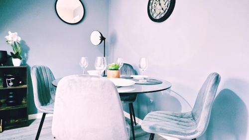una sala da pranzo con tavolo, sedie e orologio di 2 Bedroom House, Park on Doorstep, Families and Contractors Friendly, Near Parkway Station a Bristol