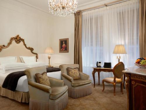 a bedroom with a bed and a desk and chairs at The Plaza in New York