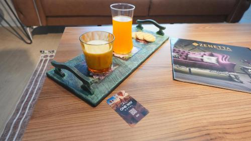 a glass of orange juice sitting on a tray on a table at One way in Kayseri