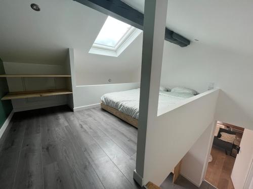 a attic bedroom with a bed and a window at Maison indépendante avec cour privative in Cars
