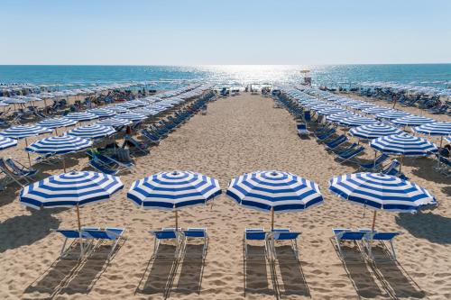 a beach filled with lots of chairs and umbrellas at Grand Hotel Continental in Tirrenia