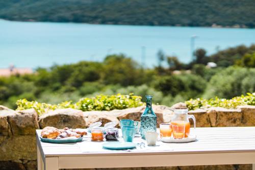 a table with food and drinks and a bottle on it at Le Ville Le Saline in Palau