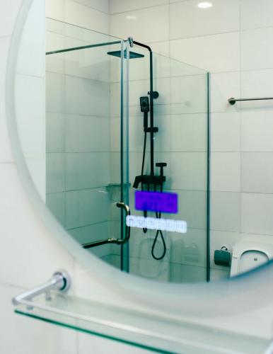 un bagno con doccia con un cartello nello specchio di HomeAway ad Abuja