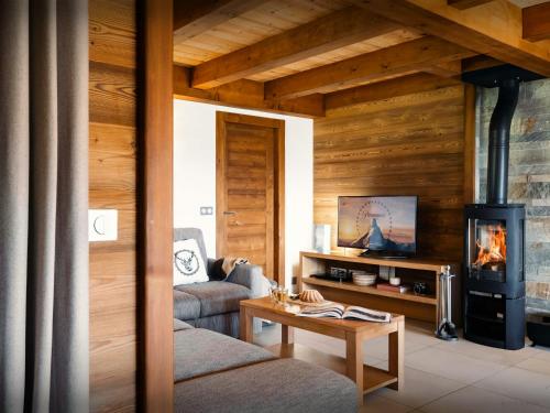 a living room with a couch and a fireplace at Pralor Le Peille - OVO Network in Manigod