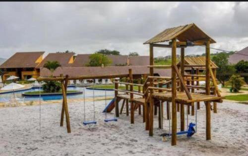 un parque infantil con columpios en la arena en winterville gravata, en Gravatá