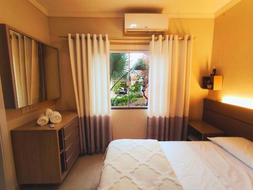a hotel room with a bed and a window at Apartamento Completo Ideal para Turismo e Compras PY in Foz do Iguaçu