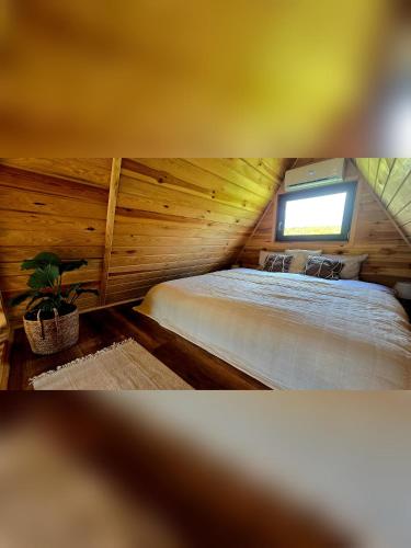 a bedroom with a large bed in a wooden room at Chill House Wierzchucinek in Wierzchucinek