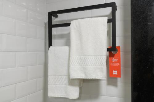 a bathroom with white towels hanging on a rack at ibis Aracaju in Aracaju