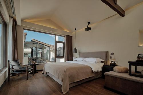 a bedroom with a bed and a large window at year after year in Lijiang