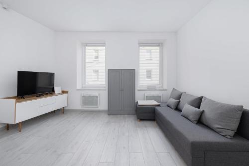 ホジュフにあるBright Studio Chorzów for 4 Guests 1,6km Silesian Stadium by Noclegi Rentersのソファとテレビのあるリビングルーム