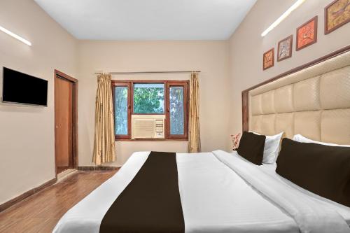 Кровать или кровати в номере Collection O Ashtley Hall Dehradun Formerly Daichi