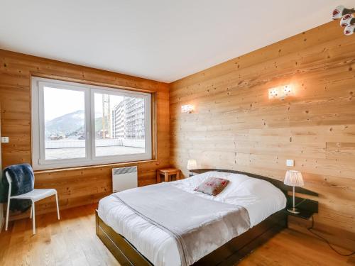 a bedroom with a bed and a window and a chair at Tignes - Appartement chaleureux 3 pièces, 8 pers., pied des pistes, proche commerces, WiFi - FR-1-411-48 in Tignes
