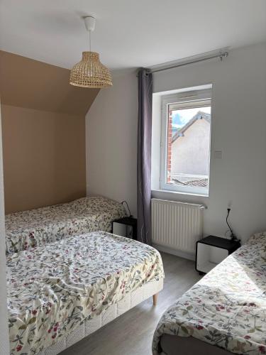 a bedroom with two beds and a window at Gîte Laurymoor - Normandie in Acquigny