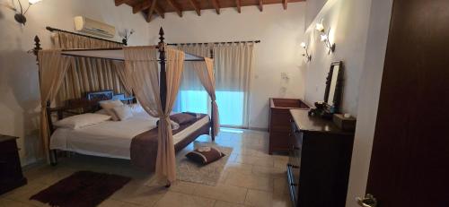 a bedroom with a canopy bed and a television at Lasa Valley Villa in Lasa