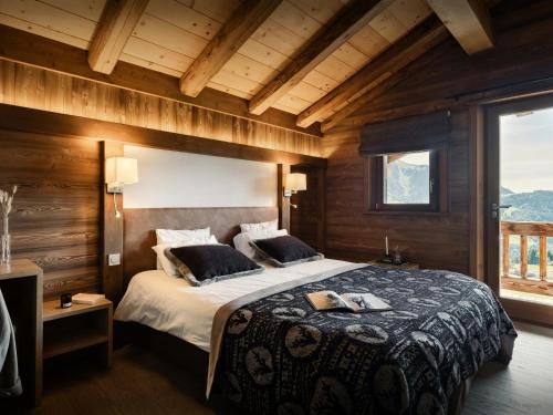 a bedroom with a large bed with wooden walls at Pralor Le Nova - OVO Network in Manigod