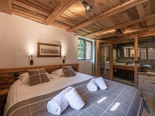 a bedroom with a large bed and a bathroom at Chalet à Chamonix avec Sauna et Jacuzzi - FR-1-343-253 in Chamonix-Mont-Blanc