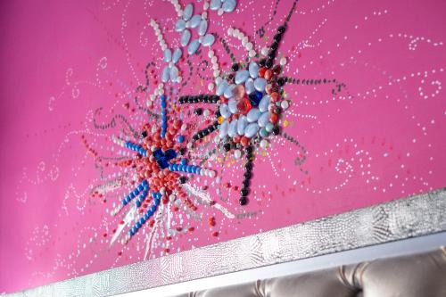a painting of a flower on a pink wall at Elysium Luxe Suites in Porto Cesareo