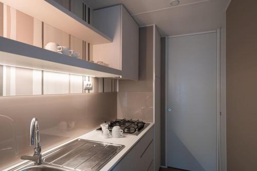 a kitchen with a sink and a stove at Ferienpark Cesenatico Mobilehome Giove für 5 Personen in Zadina Pineta