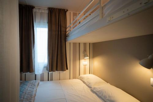 a bedroom with two bunk beds and a window at Ferienpark Cesenatico Mobilehome Giove für 5 Personen in Zadina Pineta