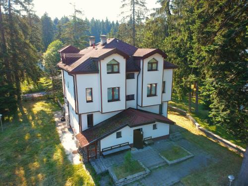 an aerial view of a house in the woods at Villa Rila Borovets with Hot Pool, Jacuzzi & Sauna by BookVillaBG in Borovets