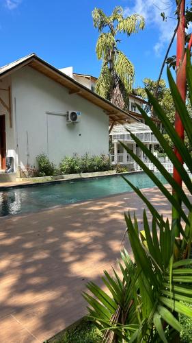 a house with a swimming pool next to a building at Вилла с бассейном и видом на рисовые поля и джунгли in Weligama