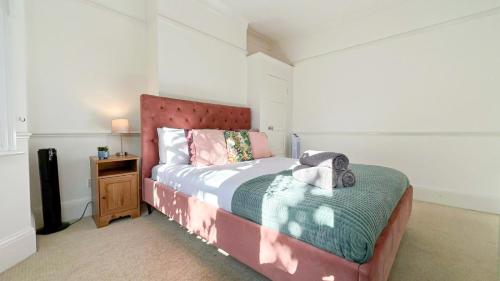 a small bedroom with a bed and a night stand at Lovely 3-Bedroom Maisonette in Hammersmith with rooftop terrace near Shepherds Bush & Ravenscourt Park by Staylio Ltd in London