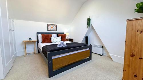 a bedroom with a bed with a black headboard at Lovely 3-Bedroom Maisonette in Hammersmith with rooftop terrace near Shepherds Bush & Ravenscourt Park by Staylio Ltd in London