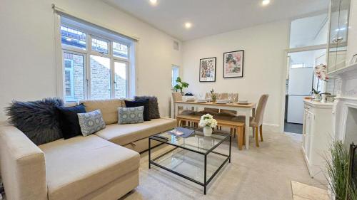 a living room with a couch and a table at Lovely 3-Bedroom Maisonette in Hammersmith with rooftop terrace near Shepherds Bush & Ravenscourt Park by Staylio Ltd in London