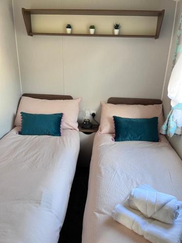 two beds sitting next to each other in a room at Lovely 3 bedroom holiday home in Seton Sand caravan park Wi-Fi Xbox in Longniddry