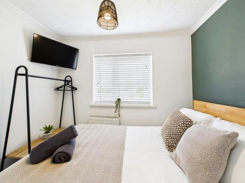 a bedroom with a bed with a television on the wall at 4 Bed House Port Talbot - Perfect For Contractors in Port Talbot