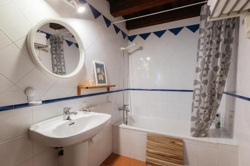 a bathroom with a sink and a tub and a mirror at El Molí Nou - Rural flats in Peñarroya de Tastavins