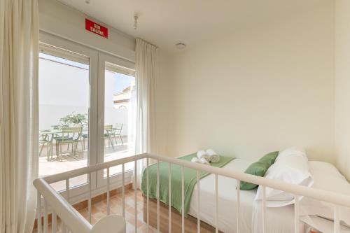 sypialnia z łóżkiem i balkonem ze stołem w obiekcie ISG Apartments Esencia de Triana w Sewilli