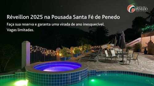 a sign for a spa with a swimming pool at night at Pousada Santa Fe de Penedo in Penedo