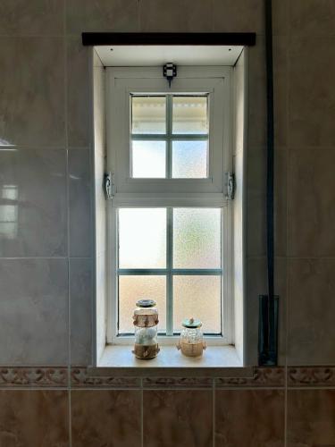 two jars sitting on a window sill in a bathroom at Casa Miramar in Tavira