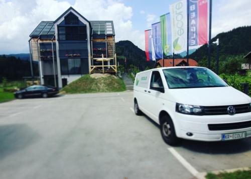 a white van parked in a parking lot in front of a building at eco boutique hotel AMS Beagle in Bled