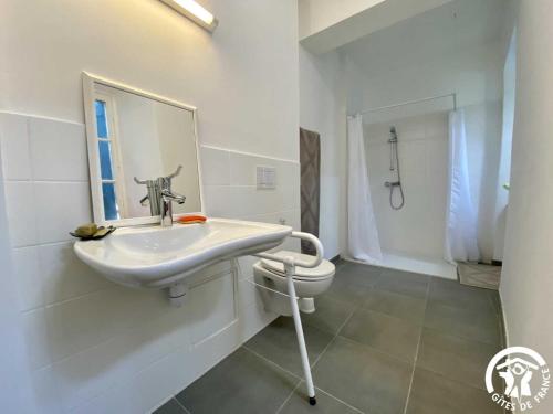 a white bathroom with a sink and a toilet at Les chambres du domaine de russol in Laure-Minervois