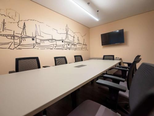 a conference room with a long table and chairs at Ed. Connext Loft (ref. Hotel Mercure Boulevard) in Curro Velho