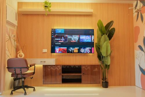 a room with a tv on a wall with a chair at N Residences in Puerto Princesa City