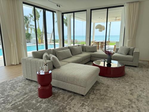 ein Wohnzimmer mit Couch und Tisch in der Unterkunft Euphoria Samui Beachfront Luxury Villa in Ban Laem Din